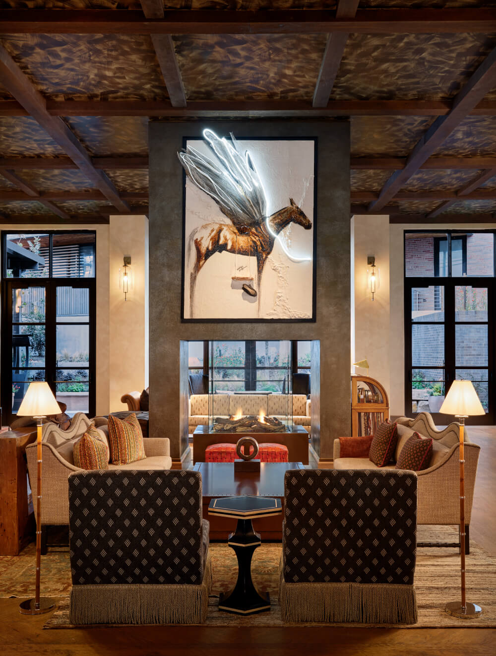 Contemporary lobby with modern seating and a striking neon artwork of a horse with illuminated wings.